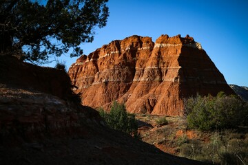 Fototapeta premium a hill of red colored rocks rises above a vast area