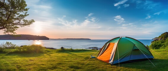 Camping tent and camping equipment on green grass with sea view background