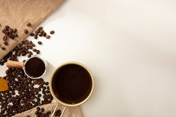 Creative minimal banner background from coffee beans. Against the white background, brown roasted coffee beans and coffee powder decorated. Empty space for design or copy space