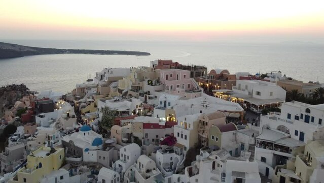 Oia village cliffside houses and hotels in Santorini,  Greece, Cinematic aerial view