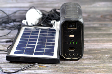 A multi purpose battery charged with a solar panel, a device that converts sunlight into electricity by using photovoltaic (PV) cells which made of materials that generate electrons - obrazy, fototapety, plakaty