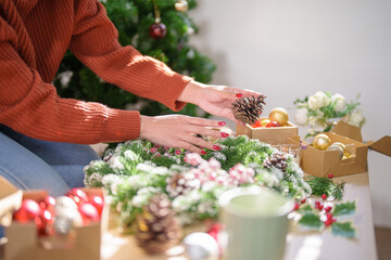 Woman making mistletoe wreath Christmas wreath decoration with hand made DIY winter greenery florist hands making Christmas wreath beautiful mistletoe.