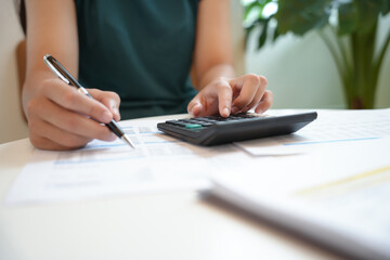 Businesswoman Accountant analyzing investment charts Invoice and pressing calculator buttons over documents. Accounting Bookkeeper Clerk Bank Advisor And Auditor Concept.