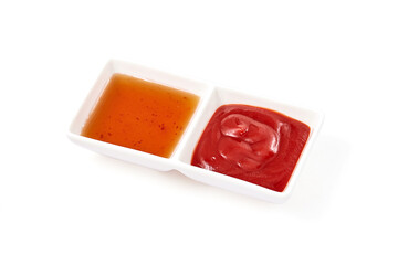 Tomato sauce (ketchup) and Hot and spicy sweet chili sauce in white ceramic sauce dip tray isolated on white background. Condiment for appetizer food.
