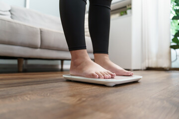 Fat diet and scale feet standing on electronic scales for weight control. Measurement instrument in...