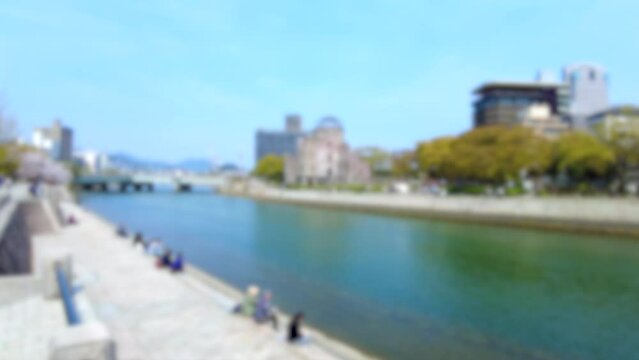 ぼかし背景素材: 多くの桜花見客が行き交う春の広島平和記念公園の元安川沿いの風景 4K 2023年3月30日