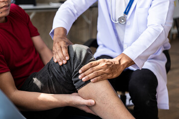 Fototapeta premium Doctor examining male patient's injured arm, stretching and exercising Doing pain therapy, physical therapist working with patient in closed clinic