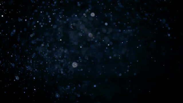 Blue dust particles flying in the air. Cinematic element for video editing. Aesthetic ambients.