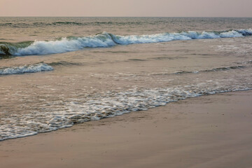 foam of sea or ocean waves against the backdrop of the setting sun