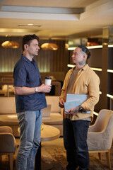 Obraz premium Serious businessmen discussing project development in office lounge area