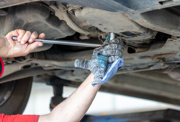 A mechanic at a car service center disassembles a CVT on a car