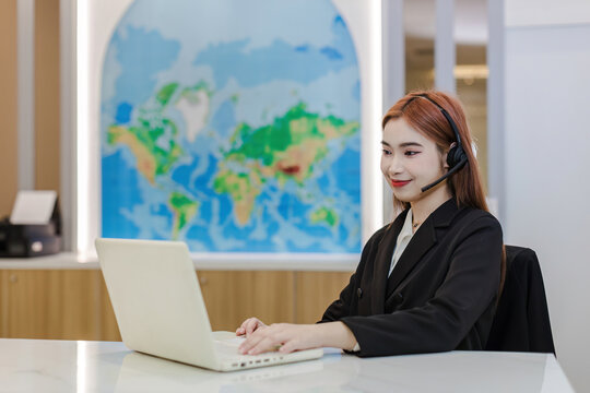 Call center business woman talking on headset. Call center worker accompanied by her team. Customer service executive working at office.	