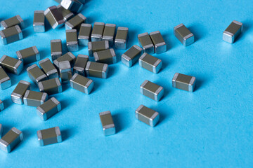 smd ceramic capacitors, on a blue table, electronic component - obrazy, fototapety, plakaty