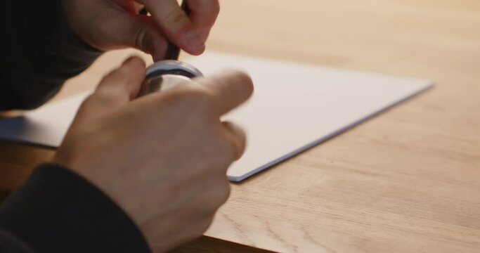 Using a left handed pencil sharpener with a pencil. Caucasian hands, close up, starting to write.