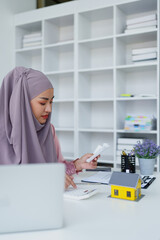 muslim woman with hijab using calculator focus on utility bills calculate check credit card receipt monthly expense.