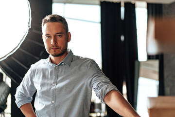 Confident young businessman standing near wooden ladder portrait