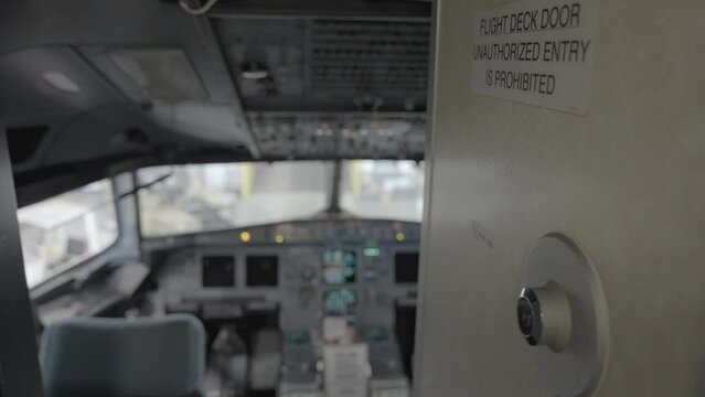 "Flight deck door Unauthorized entry is prohibited" sign and blurry view of  A320 flight deck.