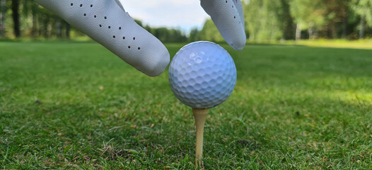 Closeup hand holding golf ball. Hand holding golf ball on golf tee