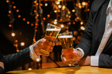 food and drink male friends are happy drinking beer and clinking glasses at a bar or pub.