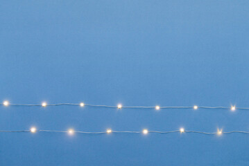 blue background with garland lights. Empty copy space for your greetings