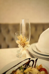 A wine glass with a floral arrangement. Serving the festive table.