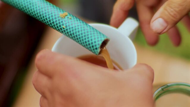 Pressed Apple Juice Coming out of a Hose to fill some Glasses