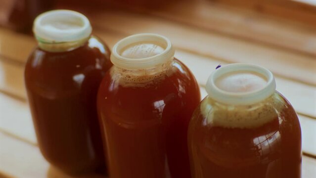 Three Bottles full of Apple Juice on a Wooden Floor