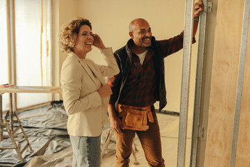 Happy home renovation: Contractor and homeowner smiling together on a property upgrade project