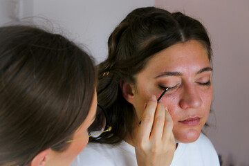 Close up of a make up artist doing bridal makeup on beautiful caucasian woman
