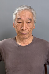 白髪混じりの60代の男性が、やや下を向いて何かを思っている