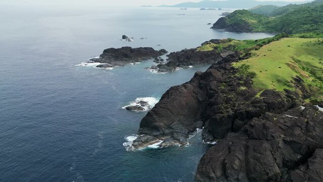 Aerial view of stunning coastal, island rocks and lush hills facing turquoise ocean waters. Baras, Catanduanes.