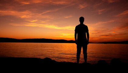 sylwetka mężczyzny medytującego na plaży przy zachodzie słońca - obrazy, fototapety, plakaty