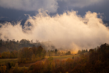 Dramatic landscape with fog in the mountains during the sunset.