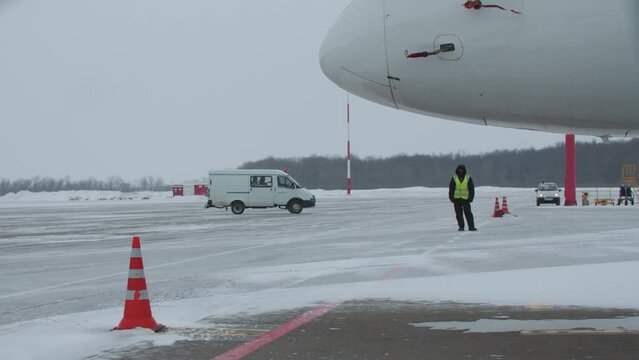 Workers in aiport on airfield - airplane on the runway - winter time
