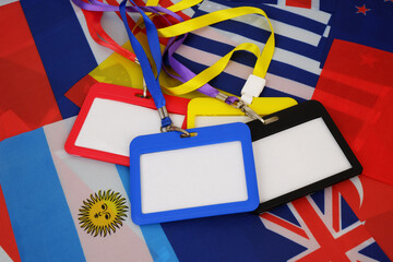 Badges with strings on national flags background. Accreditation for events concept.