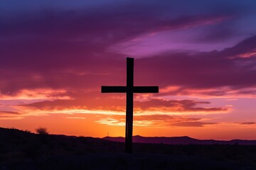Fototapeta na wymiar Silhouette of a cross on against a colorful sunset sky