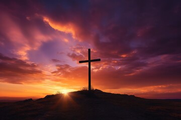 Silhouette of a cross on against a colorful sunset sky