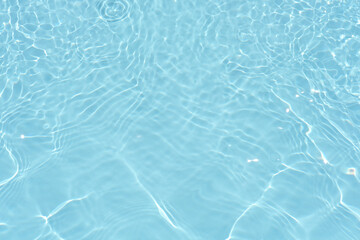 Defocus blurred transparent blue colored clear calm water surface texture with splashes reflection. Trendy abstract nature background. Water waves in sunlight with copy space. Blue watercolor shine.
