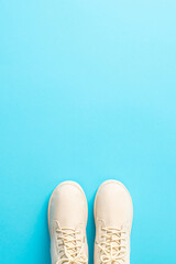 Seasonal travel symbol. Top-view vertical picture of chic women's winter boots on a snowy blue background, suggesting the way to a holiday destination with space for your message or advertisement