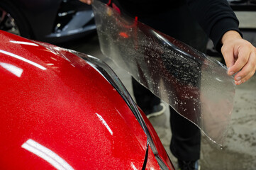 The process of applying protective vinyl film to car headlights in detailing. 