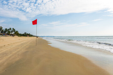 red flag on beach on sea or ocean as a symbol of danger. The sea state is considered dangerous and swimming is prohibited.