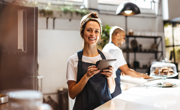 Coffee shop manager using a tablet at work