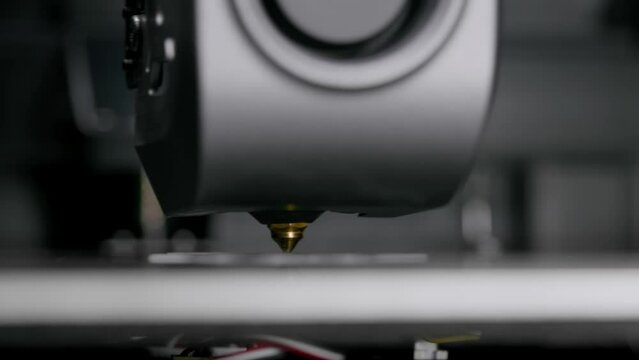 The 3D printer prints a unique product from white plastic. Working 3D printer head.