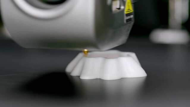 A 3D printing machine prints a technical product from plastic. Working 3D printer head.