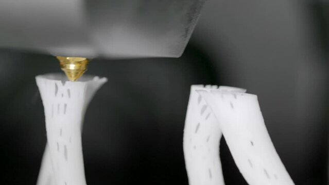 Electronic 3D plastic printer in operation. 3D printing from white filament.