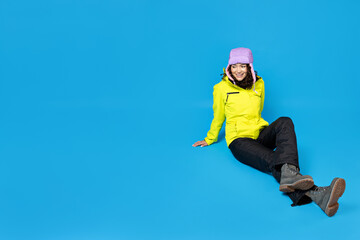 Obraz premium A girl in a ski suit on a blue background.