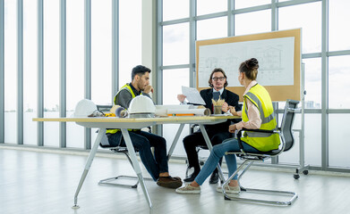 Fototapeta premium Engineer team is meeting to inspect the construction blueprint drawings, work plan and distribute work before starting the building