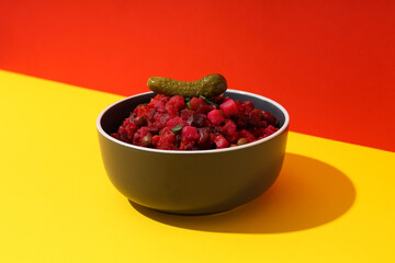 Salad vinaigrette in bowl on yellow table on red background