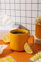 A cup of tea with lemon and a jar of honey