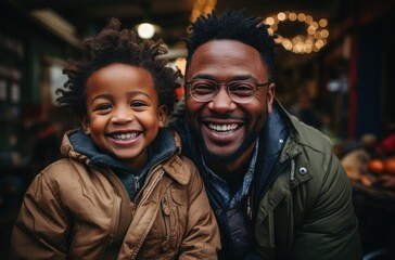 A joyful scene of a smiling African black father wearing glasses, enjoying a walk with his happy son. They are having fun and sharing special moments together. - obrazy, fototapety, plakaty